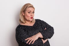 Een gelukkige aantrekkelijke te zware vrouw in studio het pruilen lippen royalty-vrije stock afbeelding Een gelukkige aantrekkelijke te zware vrouw in studio het pruilen lippen royalty-vrije stock afbeelding