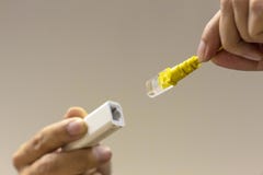 Een een het netwerkkabel van de handholding en Ethernet-hub die een ether stoppen royalty-vrije stock afbeelding Een een het netwerkkabel van de handholding en Ethernet-hub die een ether stoppen royalty-vrije stock afbeelding