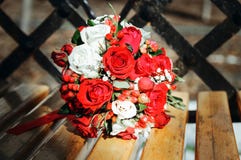 Een huwelijksboeket van rode en witte rozen op een houten bank Het bruid` s boeket royalty-vrije stock afbeelding Een huwelijksboeket van rode en witte rozen op een houten bank Het bruid` s boeket royalty-vrije stock afbeelding
