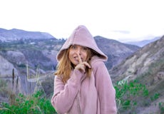 Een jong meisje in een kap drukt haar vinger aan haar lippen en kijkt mysteriously royalty-vrije stock foto Een jong meisje in een kap drukt haar vinger aan haar lippen en kijkt mysteriously royalty-vrije stock foto