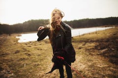 Een jong meisje stelt op de kust van een meer, werpend een sjaal op haar stock fotografie Een jong meisje stelt op de kust van een meer, werpend een sjaal op haar stock fotografie