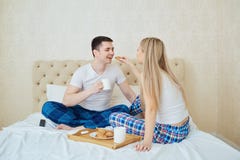 Een jong paar heeft ontbijt in de ochtend in bed stock fotografie Een jong paar heeft ontbijt in de ochtend in bed stock fotografie