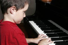 Een Jonge Jongen bij de piano royalty-vrije stock afbeelding Een Jonge Jongen bij de piano royalty-vrije stock afbeelding