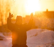 Een jongen werpt sneeuw in de hemel bij zonsondergang royalty-vrije stock foto's Een jongen werpt sneeuw in de hemel bij zonsondergang royalty-vrije stock foto's