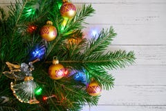 Een Kerstboomtak met speelgoed en lichten naast a wordt verfraaid die stock foto's Een Kerstboomtak met speelgoed en lichten naast a wordt verfraaid die stock foto's