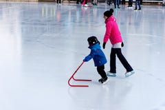 Een kind die op een openluchtpiste in Montreal leren te schaatsen royalty-vrije stock foto Een kind die op een openluchtpiste in Montreal leren te schaatsen royalty-vrije stock foto