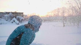 Een kind speelt in openlucht in de winter, werpt sneeuw tot de bovenkant Actieve openluchtsporten Zonsondergang stock footage Een kind speelt in openlucht in de winter, werpt sneeuw tot de bovenkant Actieve openluchtsporten Zonsondergang stock footage