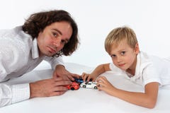 Een kindjongen die met autospeelgoed spelen met zijn papa stock foto Een kindjongen die met autospeelgoed spelen met zijn papa stock foto