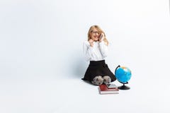 Een klein meisje, in het glazen met een bol en boeken dragen, op de telefoon spreken en en beeld die van een leraar, lachen verhe stock afbeeldingen Een klein meisje, in het glazen met een bol en boeken dragen, op de telefoon spreken en en beeld die van een leraar, lachen verhe stock afbeeldingen