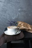 Een kop van cappuccino op een bruin servet met lavendel royalty-vrije stock afbeelding Een kop van cappuccino op een bruin servet met lavendel royalty-vrije stock afbeelding