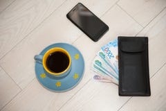 Een Kop van koffie, een portefeuille en een celtelefoon liggen op een houten tribune stock foto's Een Kop van koffie, een portefeuille en een celtelefoon liggen op een houten tribune stock foto's