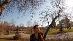 Een leuk zwanger meisje die haar buik strijken onder een boom stock video Een leuk zwanger meisje die haar buik strijken onder een boom stock video
