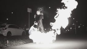 Een mens op de straat giet brand van een vlammenwerper in verschillende richtingen Koel plan in langzame motie stock footage Een mens op de straat giet brand van een vlammenwerper in verschillende richtingen Koel plan in langzame motie stock footage