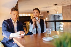 Een modieus paar drinkt ochtendkoffie bij de koffie, de jonge zakenlieden en freelancers royalty-vrije stock afbeeldingen Een modieus paar drinkt ochtendkoffie bij de koffie, de jonge zakenlieden en freelancers royalty-vrije stock afbeeldingen