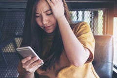 Een mooie Aziatische vrouw die slimme telefoon met het voelen van spanning bekijken royalty-vrije stock foto's Een mooie Aziatische vrouw die slimme telefoon met het voelen van spanning bekijken royalty-vrije stock foto's