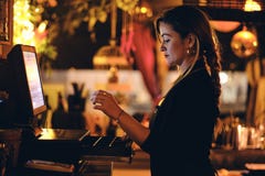 Een mooie jonge vrouw bij het bureau in een restaurant stock afbeelding Een mooie jonge vrouw bij het bureau in een restaurant stock afbeelding