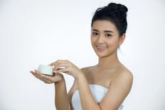 Een mooie vrouw Aziaat die een product van de huidzorg, vochtinbrengende crème o gebruiken stock foto Een mooie vrouw Aziaat die een product van de huidzorg, vochtinbrengende crème o gebruiken stock foto