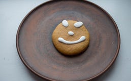 Een peperkoekkoekje met een glimlach op een plaat stock afbeeldingen Een peperkoekkoekje met een glimlach op een plaat stock afbeeldingen
