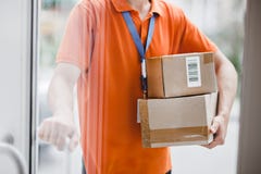 Een persoon die een oranje T-shirt en een naamplaatje draagt bevindt zich achter de glasdeur en houdt een deurhandvat en royalty-vrije stock afbeelding Een persoon die een oranje T-shirt en een naamplaatje draagt bevindt zich achter de glasdeur en houdt een deurhandvat en royalty-vrije stock afbeelding