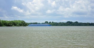 Een reusachtige boot gaat op de brede rivier Donau tegen de blauwe hemel stock fotografie Een reusachtige boot gaat op de brede rivier Donau tegen de blauwe hemel stock fotografie