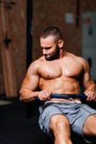Een spier volwassen mens die oefeningen op een simulator op een gymnastiekachtergrond doen Fitness, sporten, en gezond levensstij royalty-vrije stock fotografie Een spier volwassen mens die oefeningen op een simulator op een gymnastiekachtergrond doen Fitness, sporten, en gezond levensstij royalty-vrije stock fotografie
