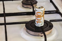 Een stapel honderd-dollar rekeningen op een gasfornuis in het centrum van gascomfort, het gas brandt niet stock foto Een stapel honderd-dollar rekeningen op een gasfornuis in het centrum van gascomfort, het gas brandt niet stock foto