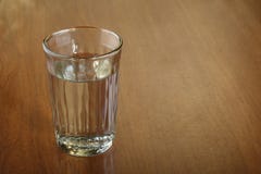 Een volledig glas water van alcohol op gekraste bruine houten lijst stock foto's Een volledig glas water van alcohol op gekraste bruine houten lijst stock foto's