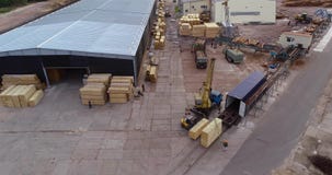 Een vorkheftruck draagt een houten straal, berijdt een vorkheftruck met een lading door de fabriek stock footage Een vorkheftruck draagt een houten straal, berijdt een vorkheftruck met een lading door de fabriek stock footage