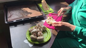 Een vrouw snijdt champignons op een scherpe raad De kaas ligt op een plaat naast het stock videobeelden Een vrouw snijdt champignons op een scherpe raad De kaas ligt op een plaat naast het stock videobeelden