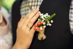Een vrouwelijke hand met een verlovingsring maakt meer butanier aan het bruidegom` s kostuum vast royalty-vrije stock foto Een vrouwelijke hand met een verlovingsring maakt meer butanier aan het bruidegom` s kostuum vast royalty-vrije stock foto
