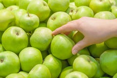 Een vrouwelijke hand neemt een groene appel stock foto Een vrouwelijke hand neemt een groene appel stock foto