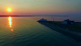 Een vuurtoren op Vreedzame oceaanbaai bij zonsondergang stock footage Een vuurtoren op Vreedzame oceaanbaai bij zonsondergang stock footage