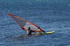 Een windsurfer berijdt op het overzees in kalme, lichte wind stock foto Een windsurfer berijdt op het overzees in kalme, lichte wind stock foto