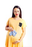 Een zwangere vrouw in een kleding en een baby weinig baby mept in haar handen royalty-vrije stock foto Een zwangere vrouw in een kleding en een baby weinig baby mept in haar handen royalty-vrije stock foto