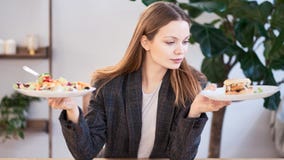 Eftertänksam kvinna som gör beslut mellan sund mat och snabbmat ?ta f?r begrepp som ?r sunt Aff?rskvinna i en kl? upp fotografering för bildbyråer Eftertänksam kvinna som gör beslut mellan sund mat och snabbmat ?ta f?r begrepp som ?r sunt Aff?rskvinna i en kl? upp fotografering för bildbyråer