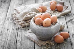 Eggs. Raw brown chicken eggs in a pot with straw Eggs. Raw brown chicken eggs in a pot with straw