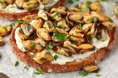 Eigengemaakte Mosselen op geroosterde bruschetta, toost met zachte kaas en kruiden stock afbeeldingen Eigengemaakte Mosselen op geroosterde bruschetta, toost met zachte kaas en kruiden stock afbeeldingen
