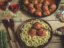 Eigengemaakte vleesballetjes in tomatensaus met deegwaren op een plaat Pan op een houten oppervlakte royalty-vrije stock foto Eigengemaakte vleesballetjes in tomatensaus met deegwaren op een plaat Pan op een houten oppervlakte royalty-vrije stock foto
