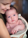 Ein altes Baby des Monats in den Armen ihrer Mutter lizenzfreie stockfotos Ein altes Baby des Monats in den Armen ihrer Mutter lizenzfreie stockfotos