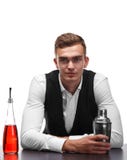 Ein attraktiver Barmixer am Stangenzähler, ein Metallschüttel-apparat, eine Flasche Whisky auf einem weißen Hintergrund stockbilder Ein attraktiver Barmixer am Stangenzähler, ein Metallschüttel-apparat, eine Flasche Whisky auf einem weißen Hintergrund stockbilder