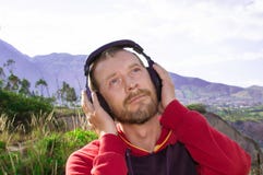 Ein bärtiger Mann hört Musik auf Kopfhörern, in der Natur stockbild Ein bärtiger Mann hört Musik auf Kopfhörern, in der Natur stockbild