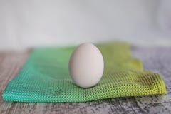 Ein Ei auf einem farbigen Stoff lizenzfreie stockfotografie Ein Ei auf einem farbigen Stoff lizenzfreie stockfotografie