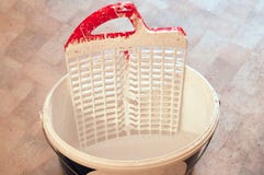 Ein Eimer mit Wildwasserbinderfarbe mit Farbwannen auf dem PVC-Boden stockfoto Ein Eimer mit Wildwasserbinderfarbe mit Farbwannen auf dem PVC-Boden stockfoto