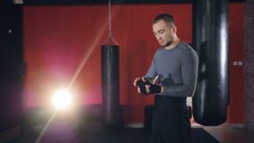 Ein einziger Boxer dehnt seinen Kopf während der Handverpackung aus stock footage Ein einziger Boxer dehnt seinen Kopf während der Handverpackung aus stock footage