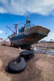 Ein Fischerboot angekoppelt an den Dockwartung eine volle Reparatur mit einem Bootshaken im Vordergrund stockfotografie Ein Fischerboot angekoppelt an den Dockwartung eine volle Reparatur mit einem Bootshaken im Vordergrund stockfotografie