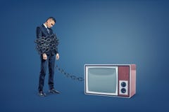 Ein Geschäftsmann steht durch eine enorme Eisenkette verklemmt, die an einen Retro- Fernsehkasten angeschlossen wird lizenzfreie stockbilder Ein Geschäftsmann steht durch eine enorme Eisenkette verklemmt, die an einen Retro- Fernsehkasten angeschlossen wird lizenzfreie stockbilder