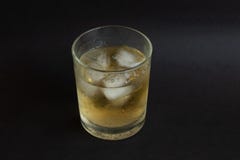 Ein Glas Whisky mit Eiswürfeln auf schwarzem Farbtabellenhintergrund stockfotografie Ein Glas Whisky mit Eiswürfeln auf schwarzem Farbtabellenhintergrund stockfotografie