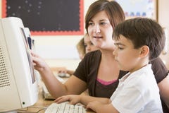 Ein Junge und sein Lehrer, die an einem Computer arbeiten stockfoto Ein Junge und sein Lehrer, die an einem Computer arbeiten stockfoto