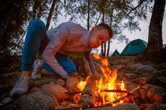 Ein junger Tourist brennt ein Feuer durch stockbilder Ein junger Tourist brennt ein Feuer durch stockbilder