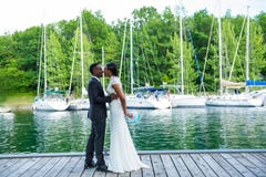 Ein junges Jungvermähltenpaar auf Dock am Jachthafen stockfotos Ein junges Jungvermähltenpaar auf Dock am Jachthafen stockfotos